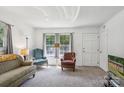 Bright living room with ample natural light from large windows, complemented by comfortable armchairs and neutral decor at 1975 Peace Rd, Fort Mill, SC 29715