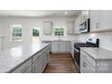 Modern kitchen featuring granite countertops, white cabinets, and stainless steel appliances at 207 Giant Oak Ave, Statesville, NC 28677