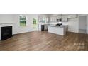 Open-concept living room and kitchen with hardwood floors and a fireplace at 207 Giant Oak Ave, Statesville, NC 28677