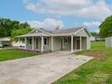 Charming single-story home with a covered front porch and long carport driveway at 210 Stonefield Ln, Salisbury, NC 28146