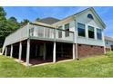 Backyard with a spacious deck, complemented by a brick foundation and white siding at 2547 Bill Thompson Rd, Lancaster, SC 29720