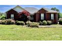 Charming brick home with beautiful landscaping, including lush greenery and a vibrant red maple tree at 2547 Bill Thompson Rd, Lancaster, SC 29720