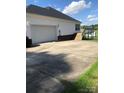 Side view of a home showing a wide driveway leading to a two-car garage and back yard at 2547 Bill Thompson Rd, Lancaster, SC 29720