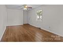 Bright living room with hardwood floors, a ceiling fan, and a large window with natural light at 322 S Vine St, Gastonia, NC 28052