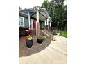 Front porch with a brick base, white columns, wrought iron railings, and landscaping at 414 Fulton Dr, Kings Mountain, NC 28086