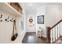 Inviting foyer with dark wood floors, a coat rack, and a glass-paneled front door at 432 Belton St, Charlotte, NC 28209