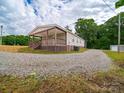 View of the home with a covered porch and gravel driveway at 4328 Camden Rd, Marshville, NC 28103