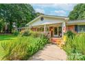 Welcoming front porch with colorful flowers and a charming brick walkway entrance at 4805 Nesbitt Rd, Monroe, NC 28112