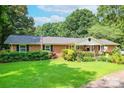 Charming brick home with a well-manicured lawn and colorful flower beds in a beautiful front yard at 4805 Nesbitt Rd, Monroe, NC 28112