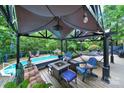 Inviting backyard patio with comfortable seating, a cozy fire pit, and a refreshing pool, perfect for outdoor relaxation at 8524 Quarters Ln, Mint Hill, NC 28227