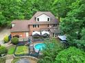 Aerial view of a backyard with a pool, a deck with a canopy, and lush landscaping at 8524 Quarters Ln, Mint Hill, NC 28227
