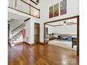Bright foyer featuring hardwood floors, a staircase, and views of a game room at 8524 Quarters Ln, Mint Hill, NC 28227