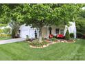 Inviting home exterior with a well-manicured lawn and cozy porch seating, perfect for relaxing outdoors at 9814 Fernspray Rd, Charlotte, NC 28215