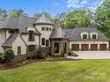 Beautiful home with stone accents, a turret, three-car garage, and lush landscaping at 10170 Enclave Cir, Concord, NC 28027