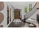 Bright foyer featuring curved staircase, wood floors, and charming architectural details at 10170 Enclave Cir, Concord, NC 28027