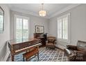 Inviting living room features classic piano, plantation shutters, and leather furnishings at 11000 Strike The Gold Ln, Waxhaw, NC 28173