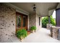Welcoming covered porch with brick accents and decorative plants, perfect for relaxing at 11000 Strike The Gold Ln, Waxhaw, NC 28173