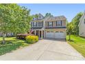 Charming two-story home with a well-manicured front yard and a two-car garage on a beautiful sunny day at 111 Tilton Dr, Mooresville, NC 28115