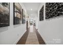 Inviting hallway featuring modern art, beautiful flooring, and a glimpse into the bright and open living spaces at 1113 Hallman Branch Ln, Lincolnton, NC 28092