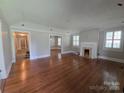 Open living room featuring hardwood floors, a decorative fireplace, large windows, and neutral paint at 1415 S York Rd, Gastonia, NC 28052