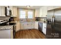 Modern kitchen with stainless steel appliances, granite countertops, and white cabinets at 169 Freeze Nw Ave, Concord, NC 28025