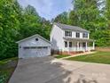 Charming two-story home featuring a detached garage, well-manicured lawn, and classic white siding at 1904 Lark Ln, Stanley, NC 28164