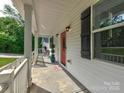Charming front porch with a red door, decorative plants, and inviting curb appeal at 1904 Lark Ln, Stanley, NC 28164