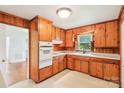 Cozy kitchen with knotty pine cabinets, and white appliances at 205 Dogwood Ln, Dallas, NC 28034