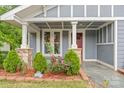 Covered front porch enhanced with elegant columns and colorful landscaping at 222 N Weldon St, Gastonia, NC 28052
