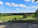 Expansive green backyard with white fencing and trees, viewed from a concrete patio on a sunny day at 2530 Sharon Rd, York, SC