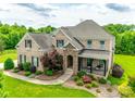 Aerial view of a brick home with manicured landscaping and a inviting front porch at 308 Hollister Estates Dr, Waxhaw, NC 28173