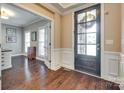 Elegant foyer boasting hardwood floors, paneled walls, and a stylish dark wood front door with glass panels at 308 Hollister Estates Dr, Waxhaw, NC 28173