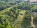 Aerial view showcases this home with expansive green spaces and surrounded by trees, offering privacy at 317 Berry Trl, Wadesboro, NC 28170