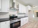 Bright kitchen with stainless steel appliances, white cabinets, black countertops and modern backsplash at 317 Berry Trl, Wadesboro, NC 28170