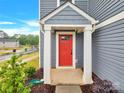 Close up of the bright red front door with white trim and siding at 3212 Coast Oak Rd, Charlotte, NC 28214