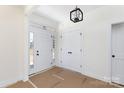 Bright foyer featuring a modern light fixture, double door closet, and front door with sidelights at 4648 Simpson Rd, Edgemoor, SC 29712