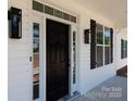 Inviting entrance showcasing a modern black front door with sidelights and stylish exterior lighting fixtures at 4648 Simpson Rd, Edgemoor, SC 29712