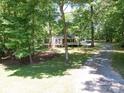 Secluded home nestled among mature trees, offering privacy and tranquility with a winding driveway at 4901 Pine Oaks Dr, Monroe, NC 28112