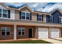 Newly built townhomes with brick facades, garages, and well-maintained lawns at 5149 Tommy Ln # 1102, Stanley, NC 28164