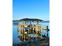 Daytime view of a waterfront dock with boat lift, seating area, and clear blue sky at 578 Stonemarker Rd, Mooresville, NC 28117