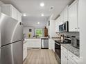 Bright kitchen features white cabinetry, stainless steel appliances, and granite countertops for a modern and clean design at 584 Lamorak Pl, Richburg, SC 29729