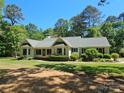 Charming single-story home featuring a well-manicured lawn, lush greenery, and a welcoming screened porch at 5903 Wm Griffin Rd, Monroe, NC 28112