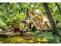 A-frame home with a backyard patio surrounded by trees and greenery at 6516 Sharon Hills Rd, Charlotte, NC 28210