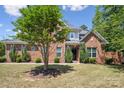 Brick home with a manicured lawn, mature landscaping, and classic architectural details at 907 Ospre Ln, Fort Mill, SC 29708