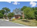 Exterior of a charming brick home with an attached garage, landscaping, and mature trees at 907 Ospre Ln, Fort Mill, SC 29708