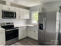 Modern kitchen featuring stainless steel appliances, white cabinets, quartz countertops, and hardwood flooring at 106 E Gibbs St, Dallas, NC 28034