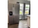 Spacious kitchen with stainless steel refrigerator, and windows with decorative curtains for a bright, open feel at 106 E Gibbs St, Dallas, NC 28034