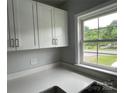Bright kitchen featuring white cabinets and countertops, a stainless steel sink, and a window with a scenic view at 106 E Gibbs St, Dallas, NC 28034