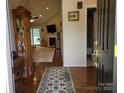 Inviting entryway with hardwood floors, decorative rug, and a view into the cozy living room at 1132 Preakness Nw Ct # 24, Concord, NC 28027