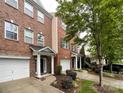 A beautiful brick townhome with a one-car garage, manicured landscaping, and a welcoming entrance, captured on a bright, overcast day at 1295 Amber Ridge Nw Rd, Concord, NC 28027